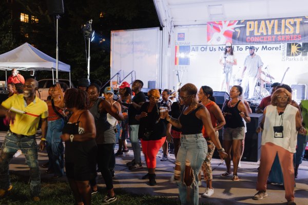People dancing in front of stage at Playlist in the Park event in Durham.