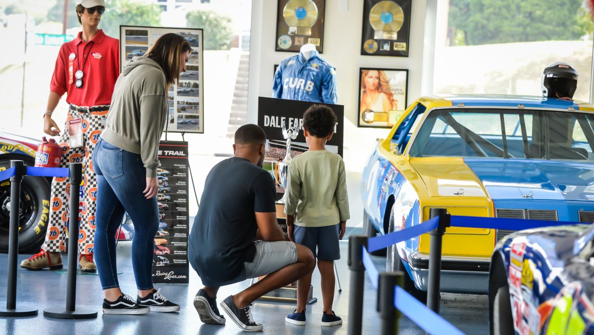 Family looking at NASCAR display at Curb Motorsports Museum.
