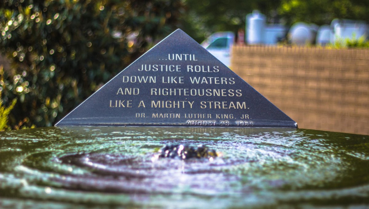 Bubbling fountain in front of plaque showing a Martin Luther King Jr. quote in garden