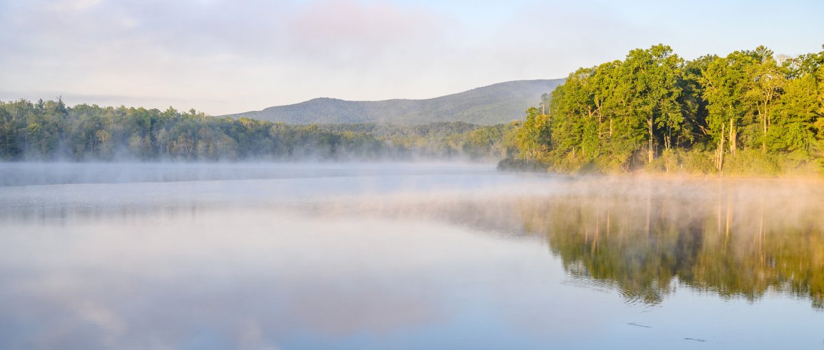 Price Lake with mist over water and trees and mountains in background