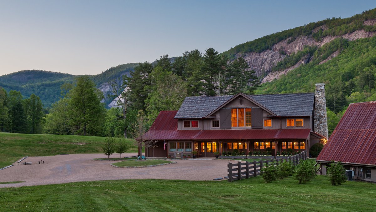 Exterior of restaurant with sheer cliffs in background during dusk.