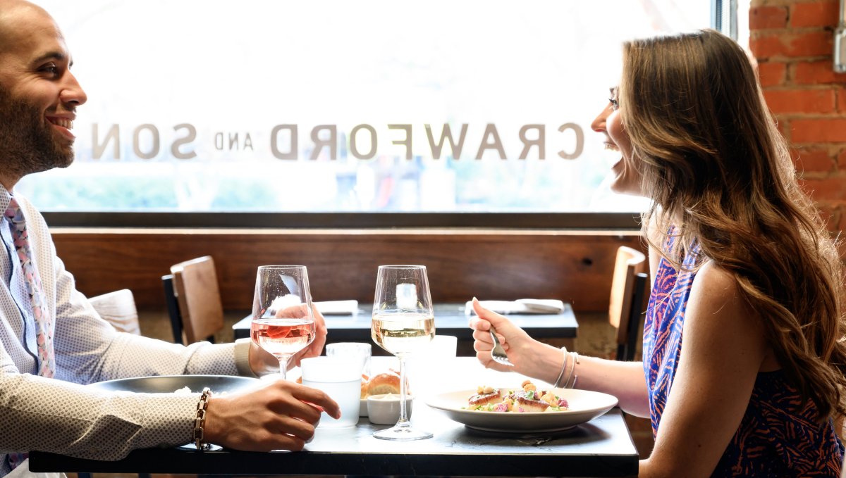 Couple dining at restaurant smiling and laughing.