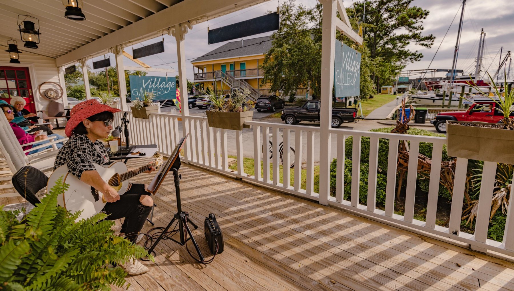 Musician playing guitar on porch of Ol' Front Porch Music Festival