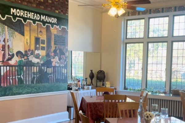 Bed and breakfast dining room with Morehead Manor mural on wall.