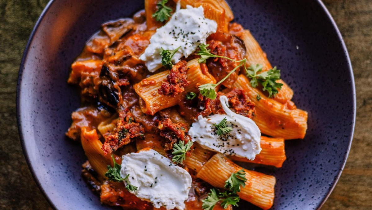 Overhead, closeup shot of pasta and red sauce meal in a blue dish