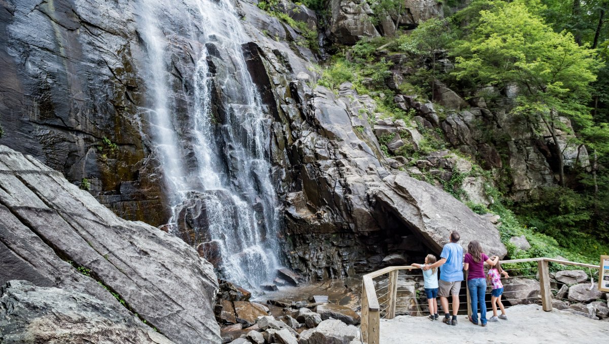 Family at base of waterfall looking up at grand cascade