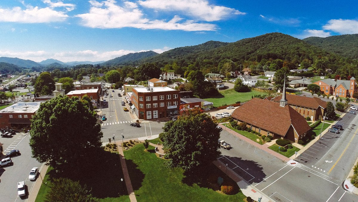 Aerial look at downtown Burnsville with buildings and squares with mountains in distance