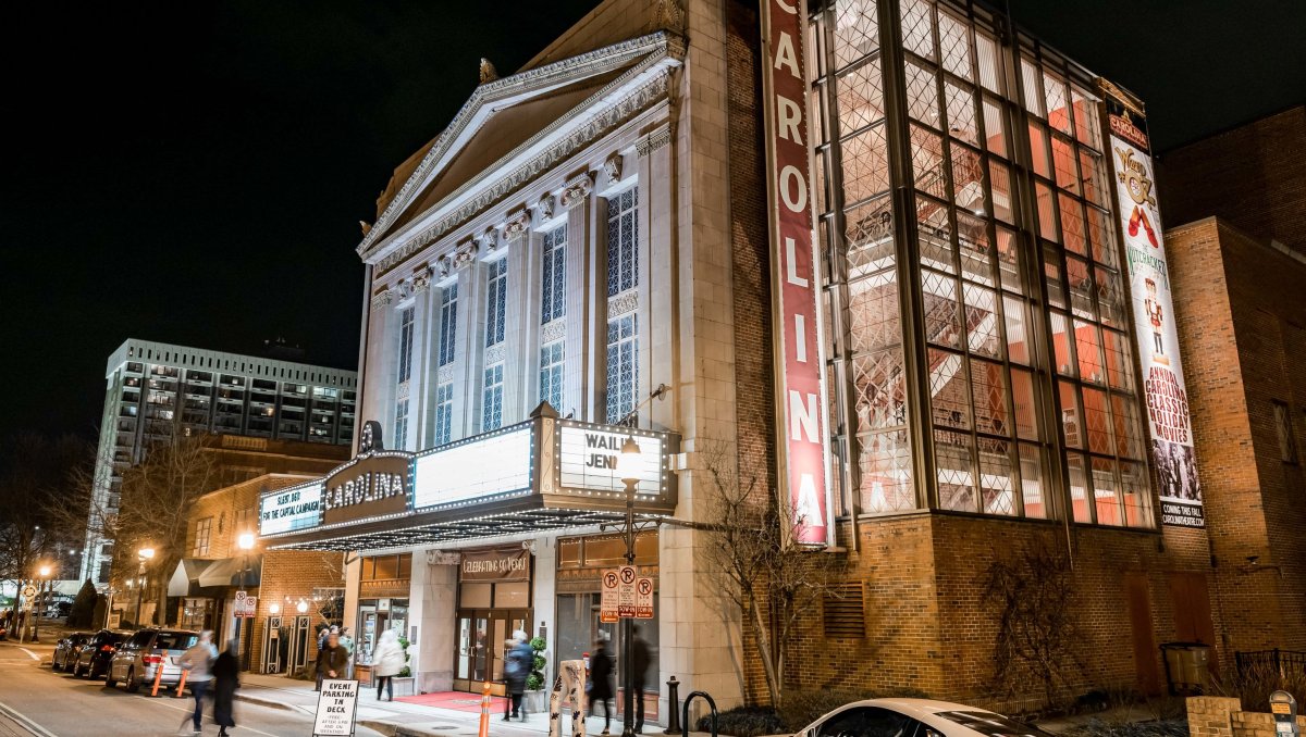 Exterior of grand Carolina Theatre building lit up at night