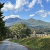 Backroad winding through countryside with mountains in background