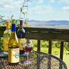 Various bottles of wine sitting on table with view overlooking mountains