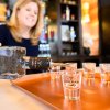 Woman pouring shot glasses full in liquor at a bar