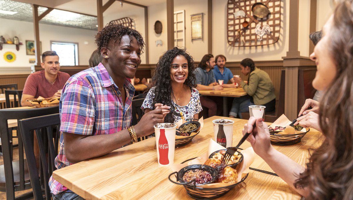 Friends having North Carolina-inspired meal inside restaurant at Carowinds.