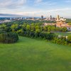 Aerial view of Dorothea Dix Park with Raleigh skyline in distance during daytime