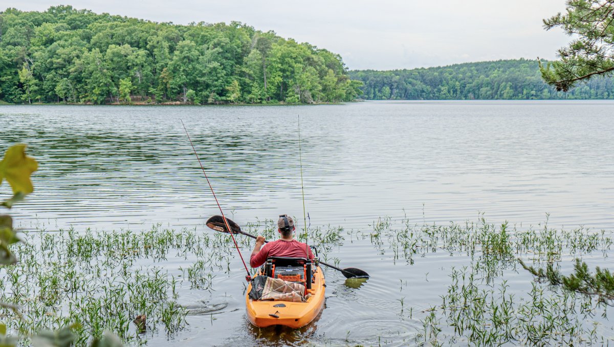 Man in kayak fishing on Badin Lake in Uwharrie National Forest, North Carolina.