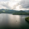 Aerial view of unspoiled lake surrounded by mountains and trees.