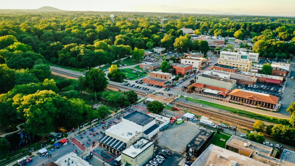 Aerial of town of Belmont, NC, with mountains in distance.