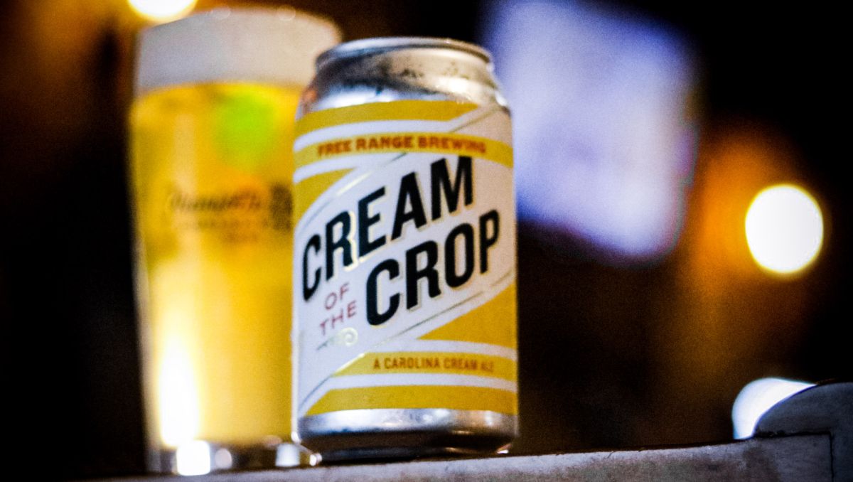 Yellow beer can displayed in front of pint of beer