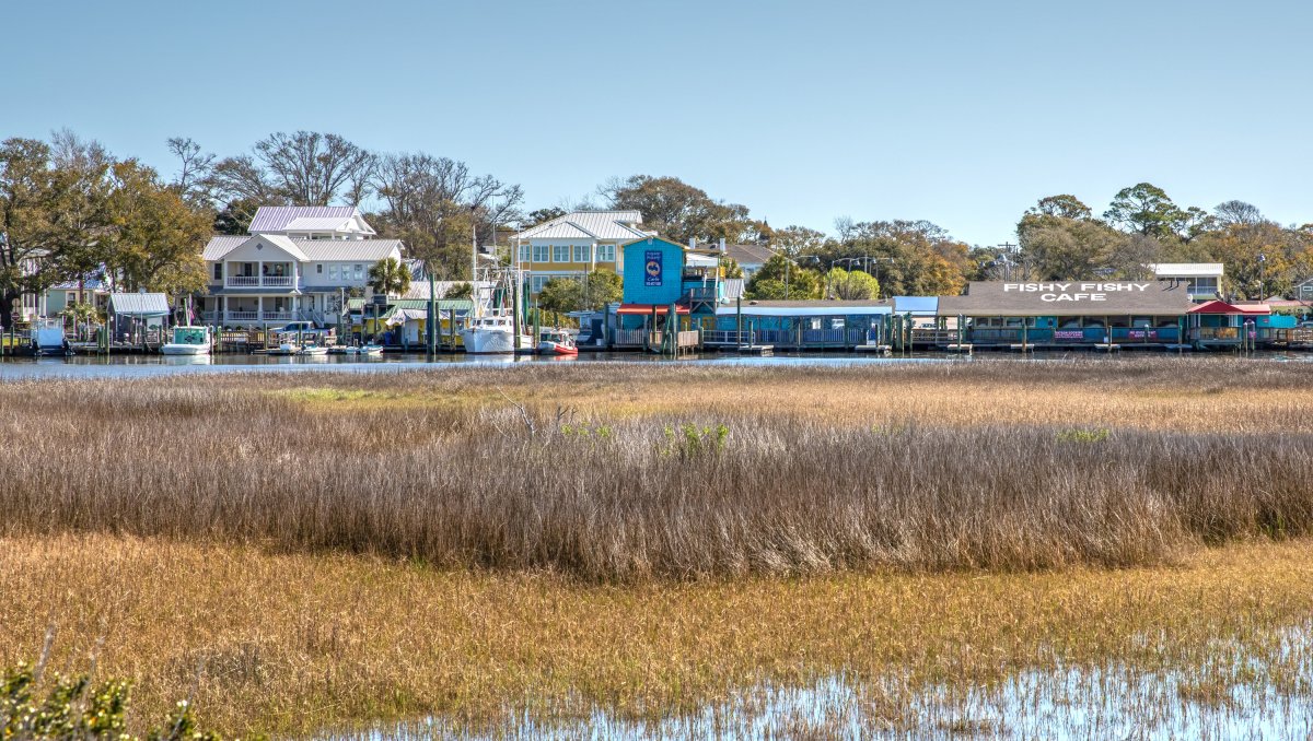 Row of waterfront restaurants with sea oats and marsh in foreground