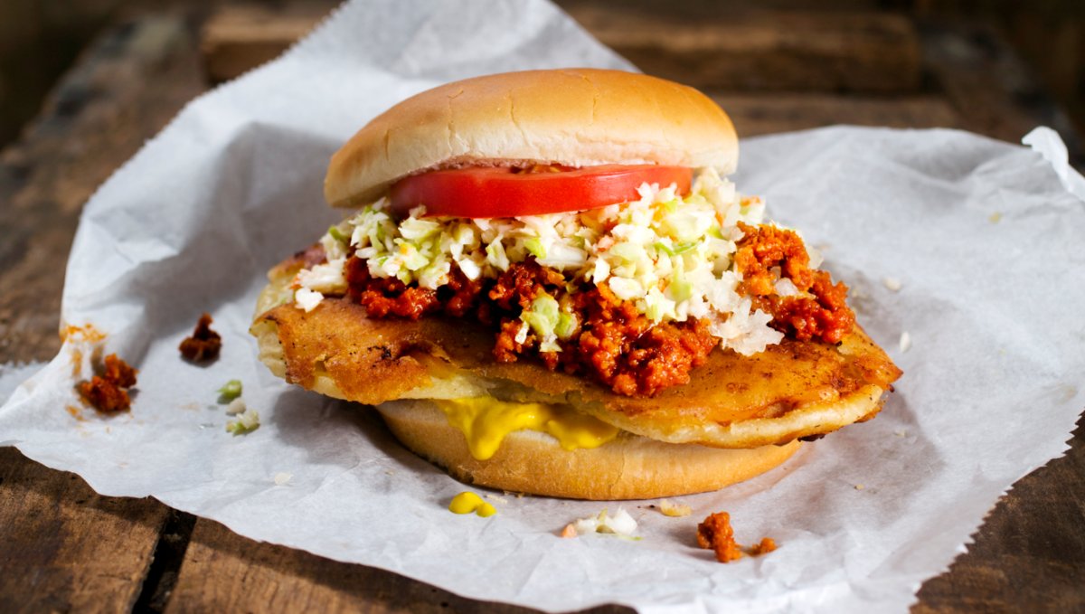 Pork chop sandwich on wax paper sitting on table