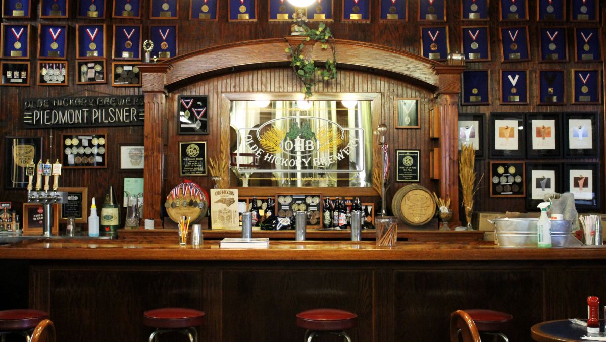 Empty bar at Olde Hickory Brewery with medals hung on wall