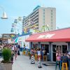 People mingling on boardwalk Carolina Beach boardwalk during daytime with Ferris wheel in background