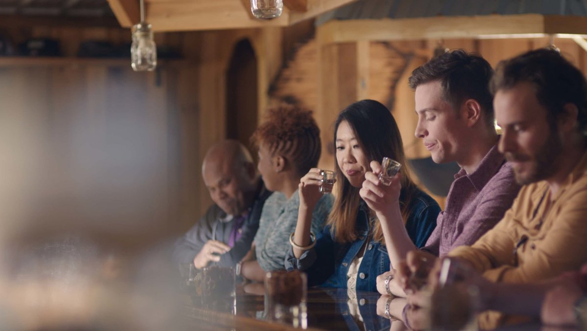 People sitting at bar tasting moonshine at Broadslab Distillery