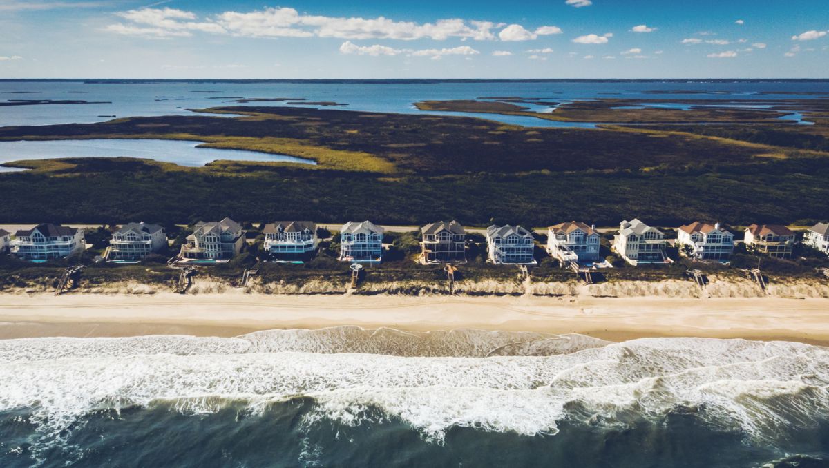 Aerial of vacation rentals on beach with sound in background