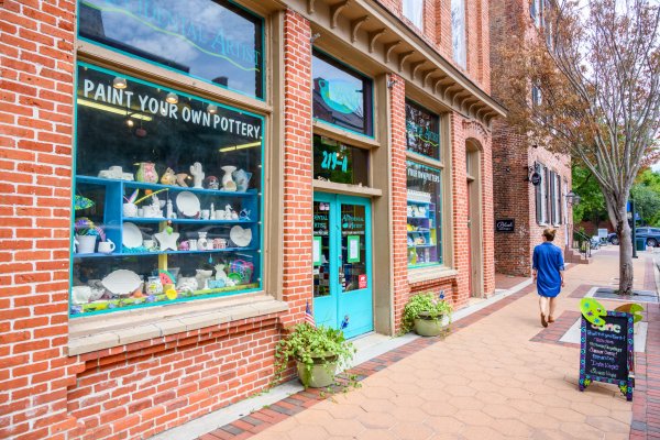 Woman walking on sidewalk window shopping in charming downtown